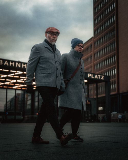 Free Elderly couple walking at Berlin's Bahnhof in winter, capturing urban life and fashion. Stock Photo