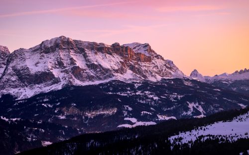 Free Breathtaking view of the Dolomites at sunset with snow-covered peaks and vibrant sky colors. Stock Photo