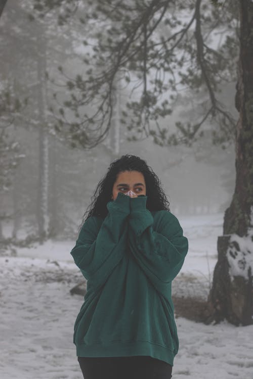 Woman Wearing Green Jumper in a Forest in Winter 