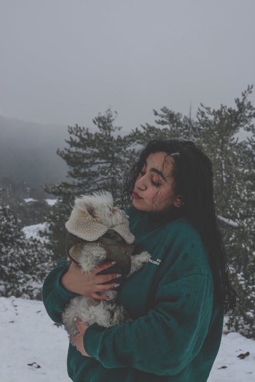 Woman Holding a Puppy in Winter 