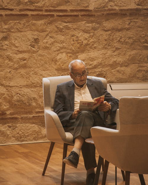 Elderly Man Sitting and Reading Book about Ataturk