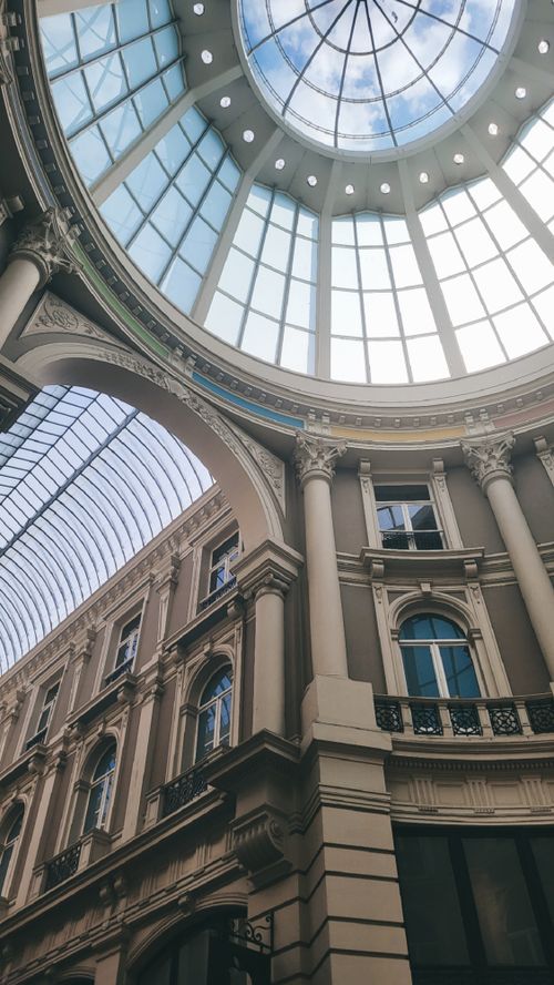 Free Low-angle shot of a glass dome ceiling in a historic shopping mall interior. Stock Photo