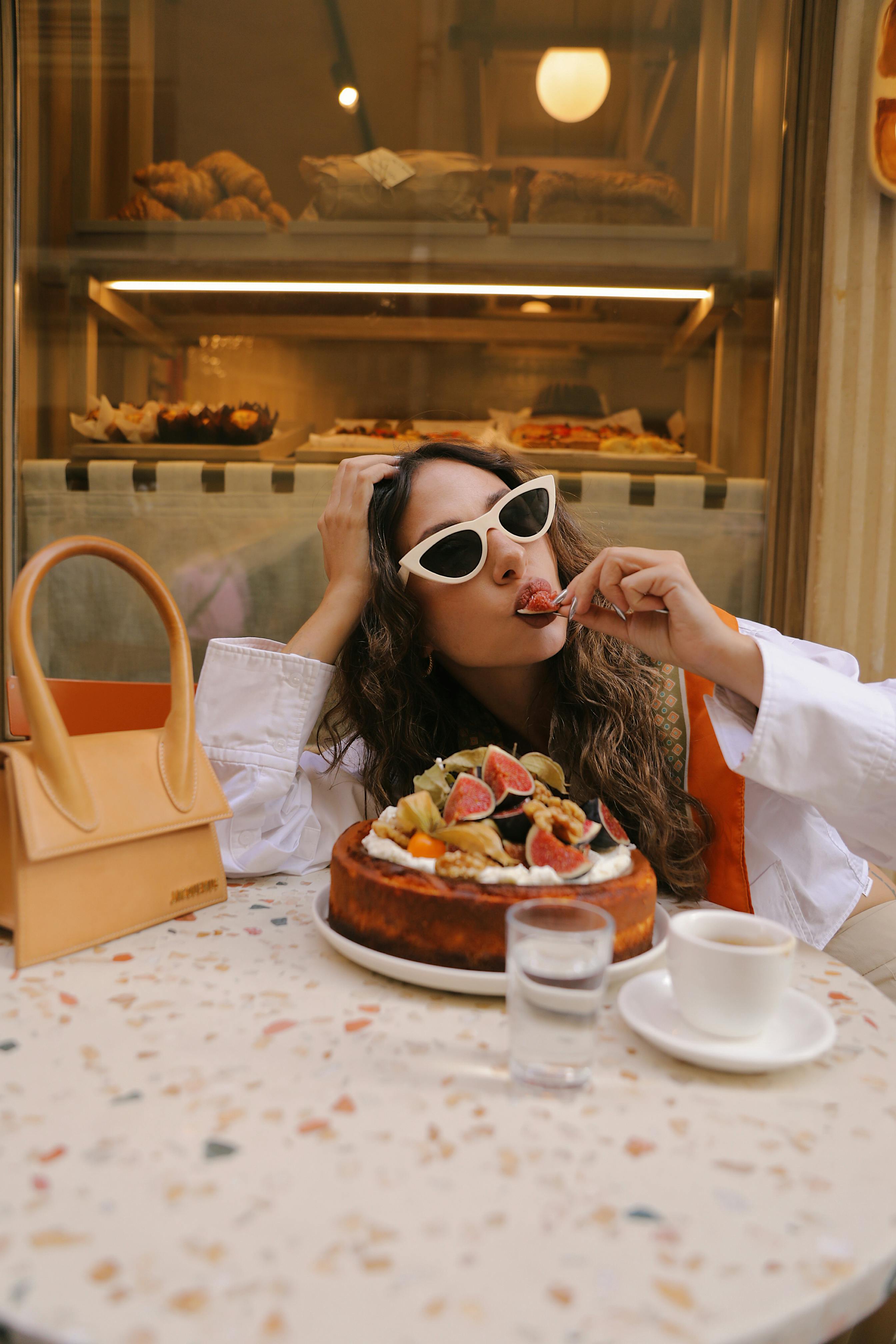 Fashionable woman indulging in a cake at a stylish café in Istanbul, Türkiye.
