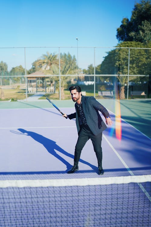 Man in Suit Playing Tennis