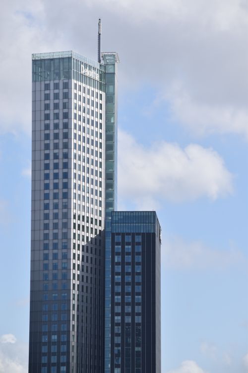 Free A sleek skyscraper set against a cloudy sky in Rotterdam, showcasing modern architecture. Stock Photo