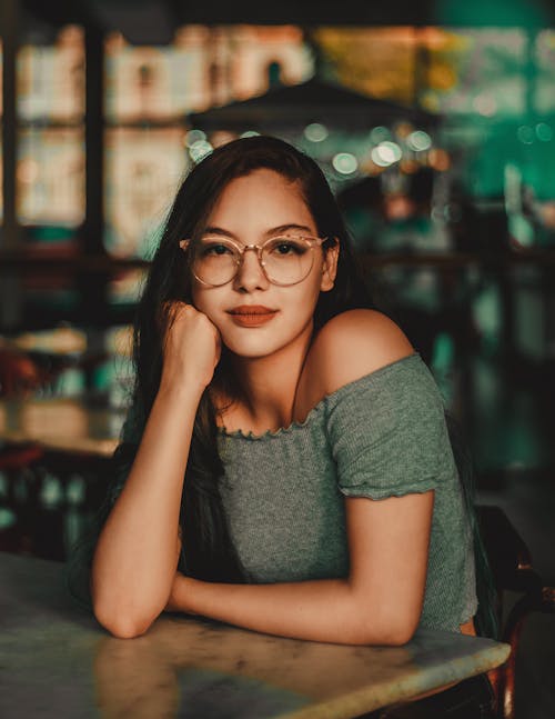 Woman Wearing Eyeglasses Sitting Beside Table