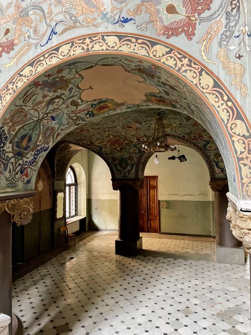 Free Explore an ornate hallway with detailed mosaic ceilings and classic columns. Stock Photo