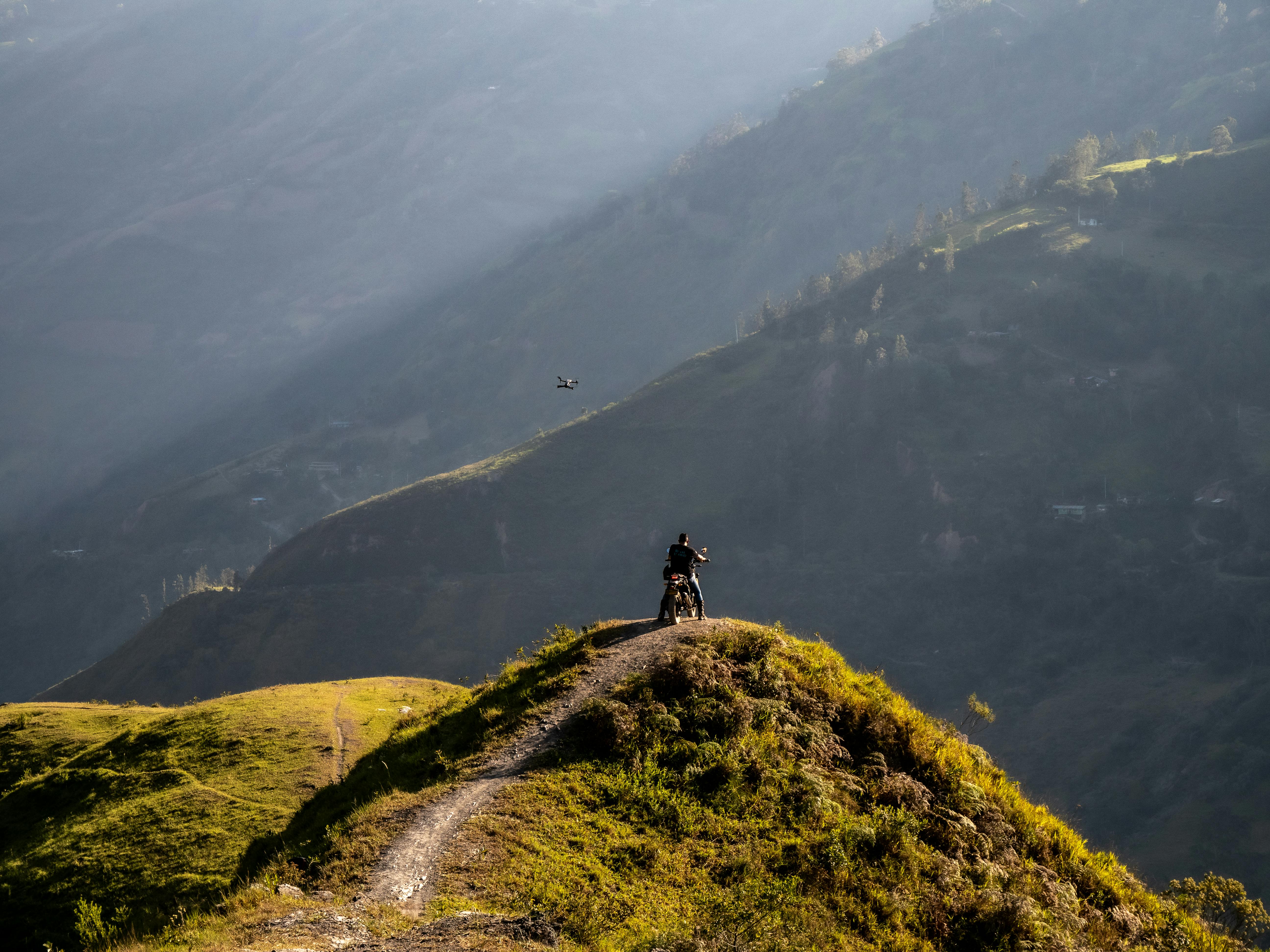 Solo traveler hiking through green mountains in Colombia, with a misty valley in the background