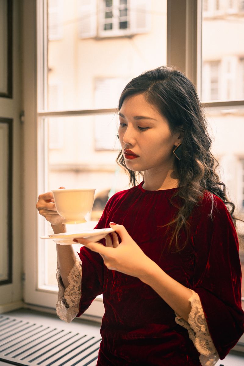 Ad footage still: woman holding a coffee cup by a window — photo by Weijia MA on Pexels