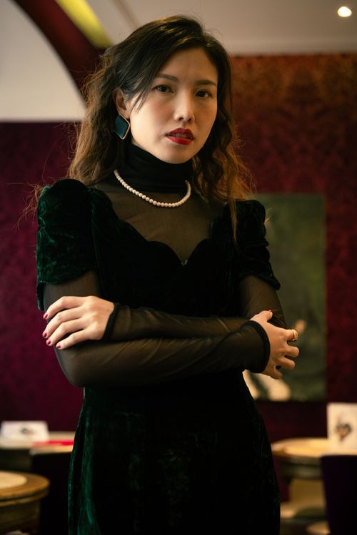 Free A stylish woman in a dark velvet dress posing elegantly indoors with a classic look. Stock Photo
