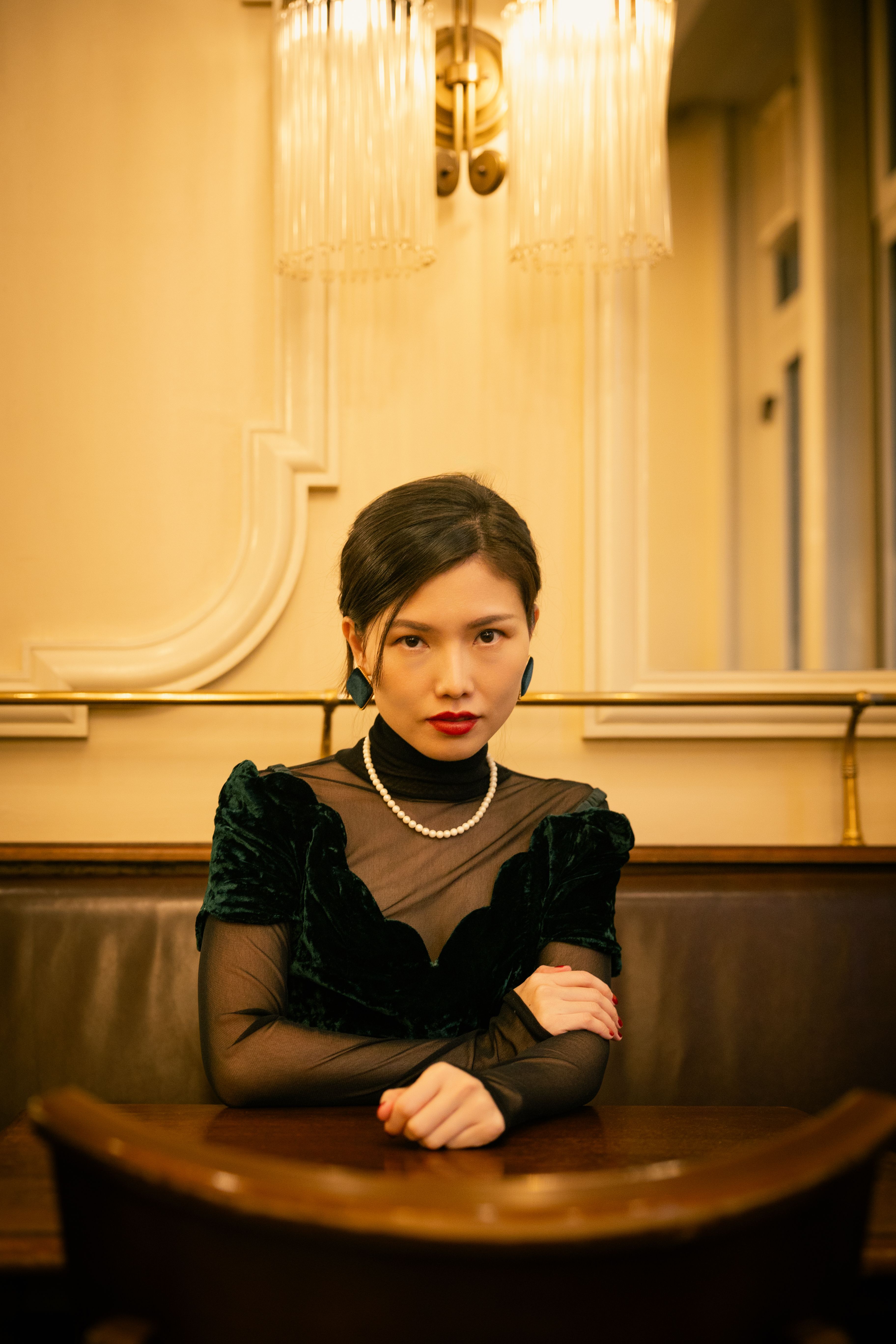Elegant Woman Wearing a Black Dress and Red Lipstick Sitting at a Table   Free Stock Photo