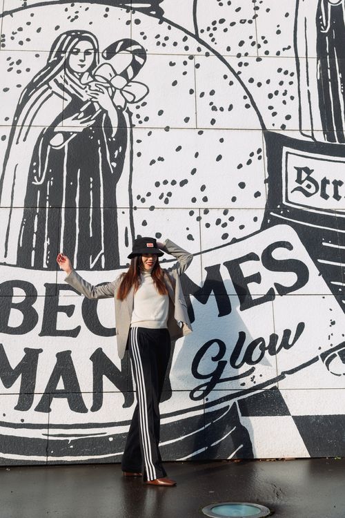 Free Fashionable woman posing with graffiti backdrop on city street. Stock Photo