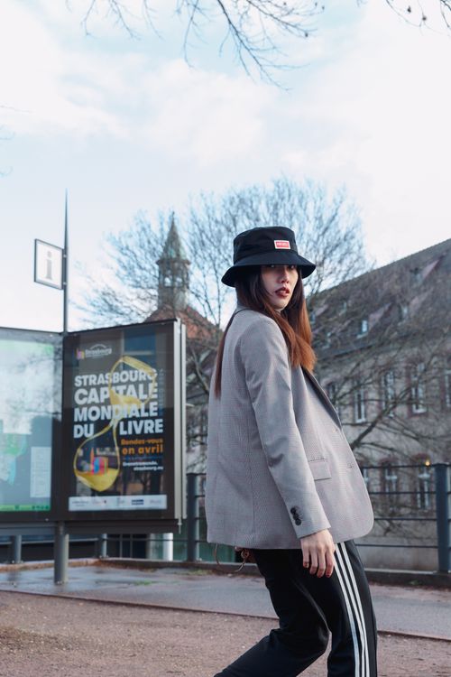 Free Trendy woman in a hat walks past an urban street in Strasbourg with city views. Stock Photo
