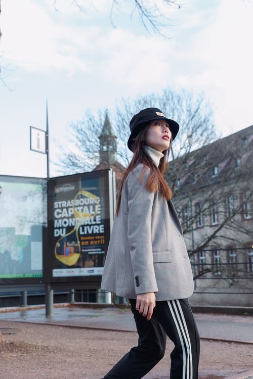 Free Young woman walking in Strasbourg showcasing modern urban fashion on a city street. Stock Photo
