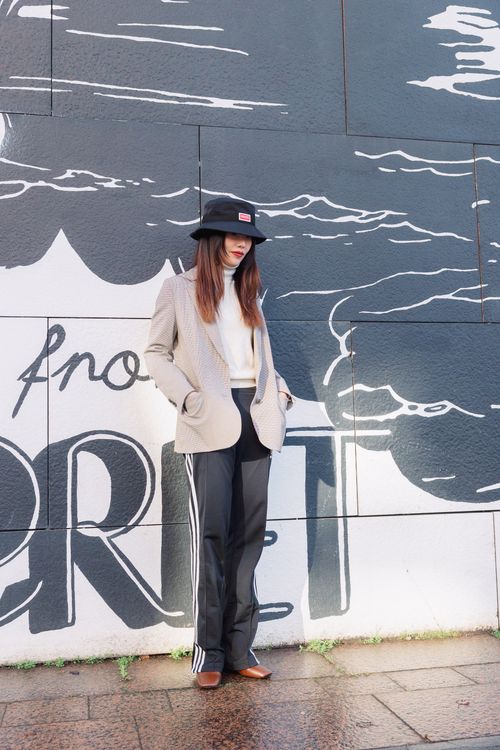 Free Stylish woman posing against graffiti wall in city street under sunlight. Stock Photo