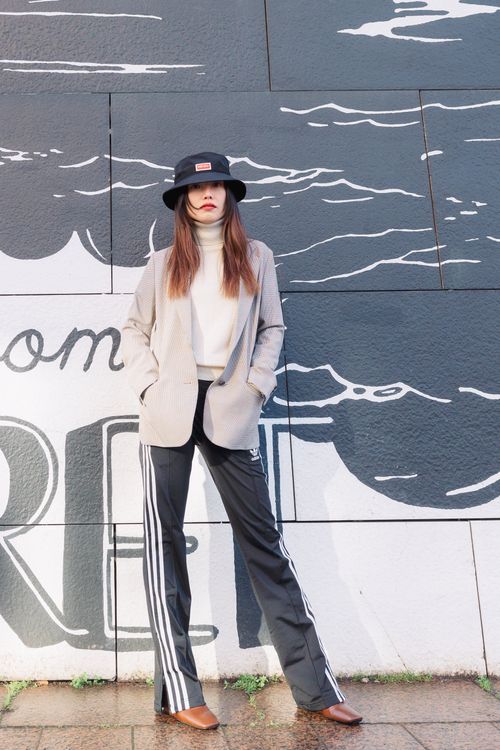 Free Fashion-forward woman in chic attire posing against a graffiti wall. Stock Photo