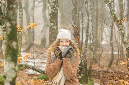 Portrait of Woman in Hat and Scarf in Forest in Winter