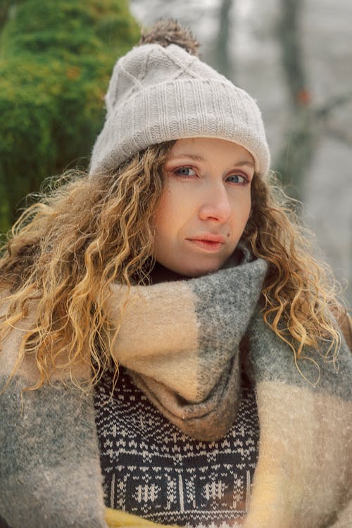 Portrait of a Pretty Blonde Wearing a Knit Hat and a Fluffy Scarf