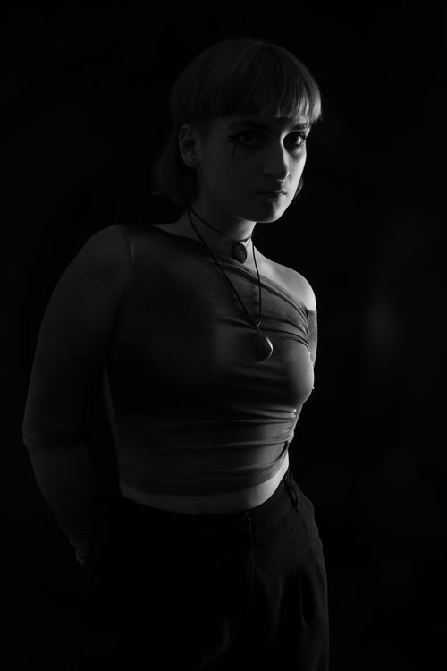 Free Elegant black and white portrait of a fashionable woman posing confidently with necklaces in a studio setting. Stock Photo