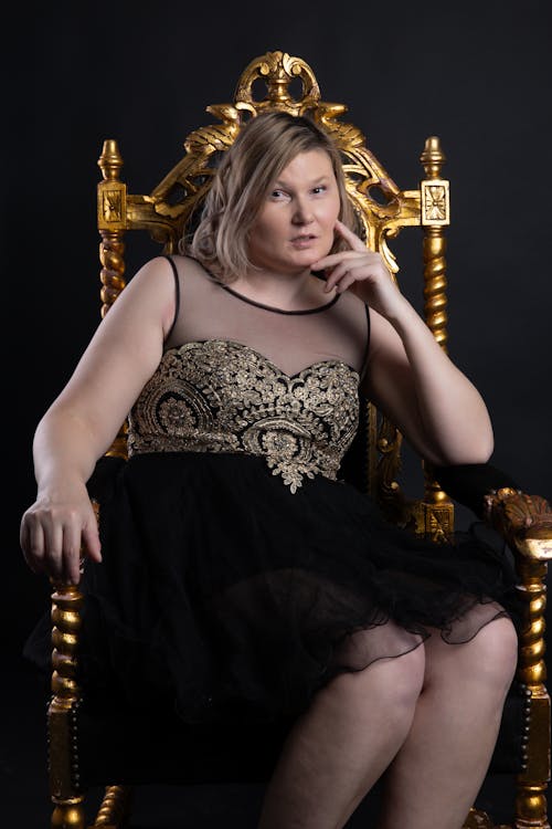 Woman in Black Dress on Golden Throne