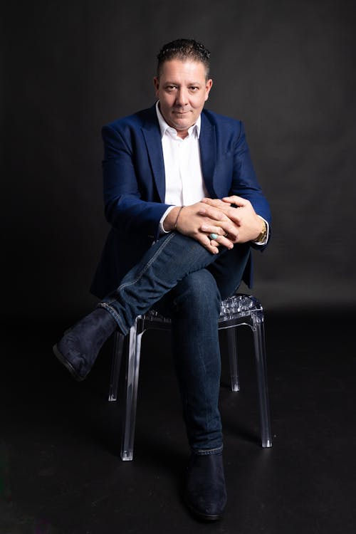 Elegant Man Sitting on Chair in a Studio 