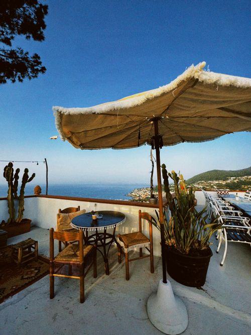 Free A peaceful rooftop terrace with sunbeds and an umbrella, offering a breathtaking sea view. Stock Photo