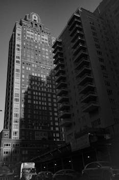 Black and white photo of modern skyscrapers in a bustling urban city center.