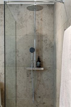 Contemporary shower area with gray tiles and minimalist design featuring glass enclosure.
