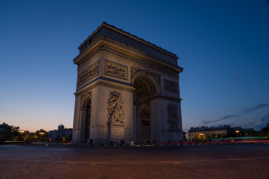 Captivating twilight shot of the Arc de Triomphe in Paris, with a dramatic sky background.