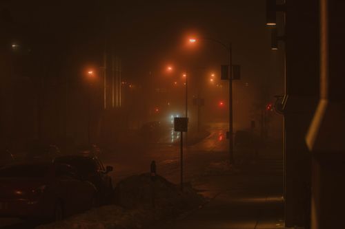 Free A foggy Milwaukee street at night illuminated by streetlights, creating an eerie urban ambiance. Stock Photo