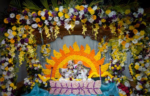 A flower arrangement with a ganesh statue on top