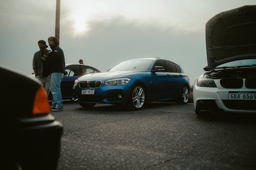People Standing by Blue BMW