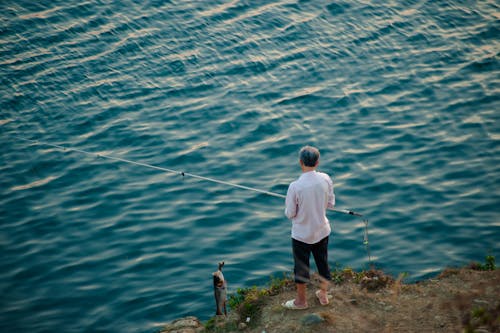 adam, ayakta durmak, Balık tutmak içeren Ücretsiz stok fotoğraf