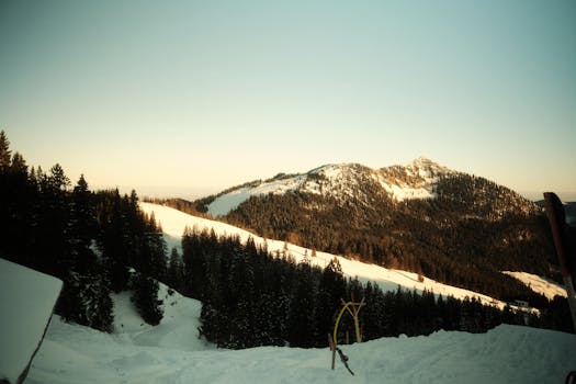 Beautiful winter sunrise over snow-covered mountains and forest in Schliersee, Germany.
