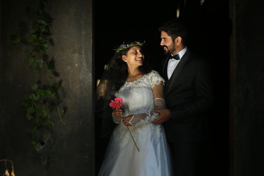 A joyful bride and groom sharing a romantic moment indoors with natural light.