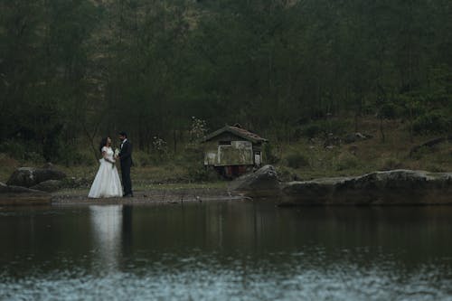 Newlyweds Standing Together by Lake