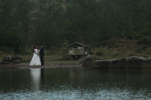 Free A serene wedding scene in a forest setting by a lake, capturing a couple's special moment. Stock Photo