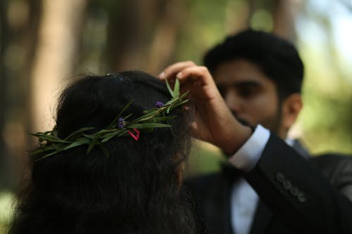 Man Putting Leaved Wreath on Woman Head