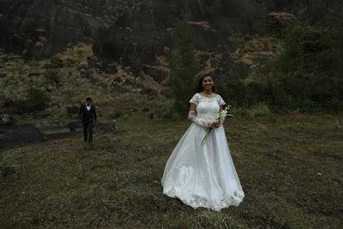 Smiling Newlyweds Standing and Walking on Grassland