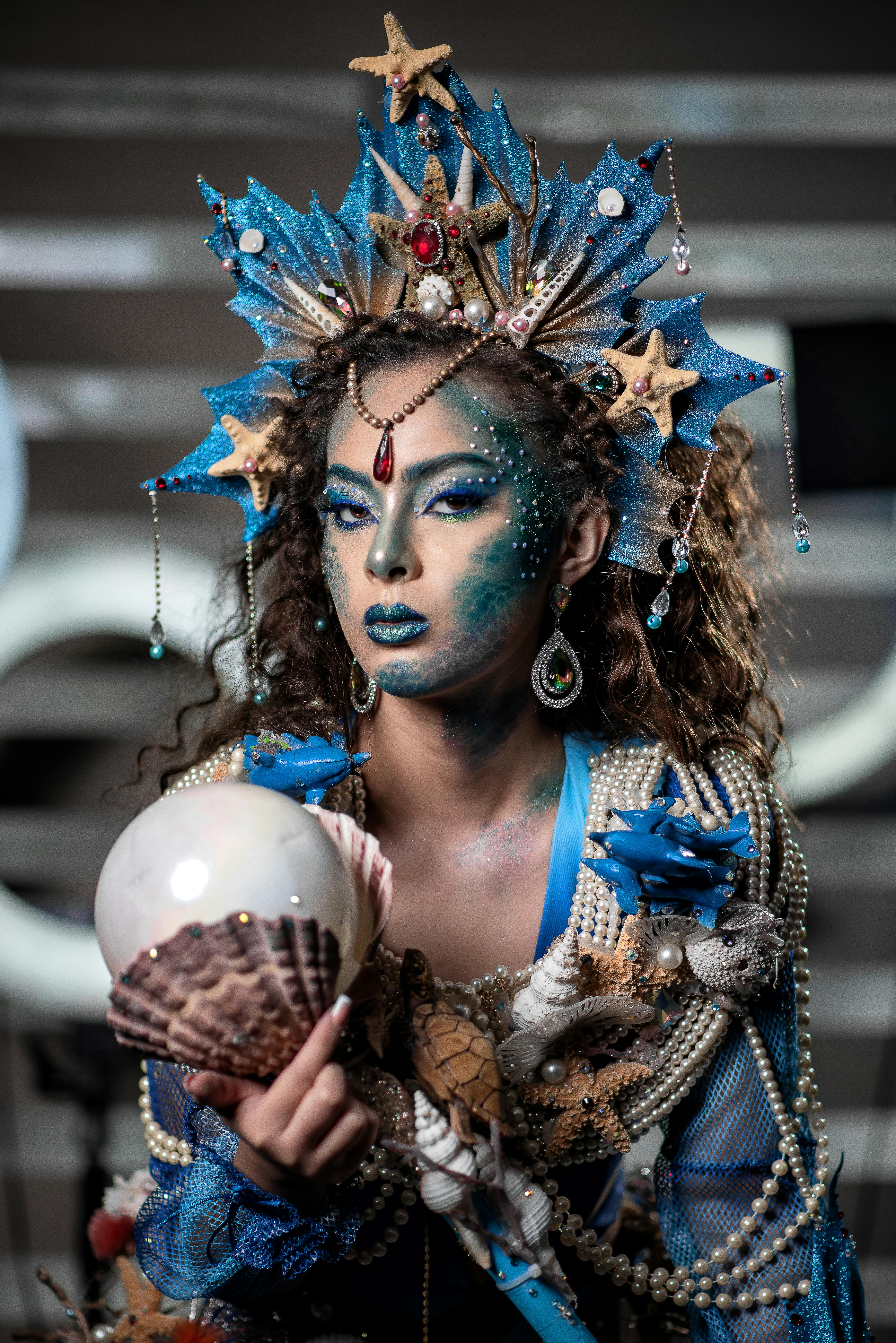 Detailed portrait of a woman in a mermaid-themed costume with intricate face paint and accessories.