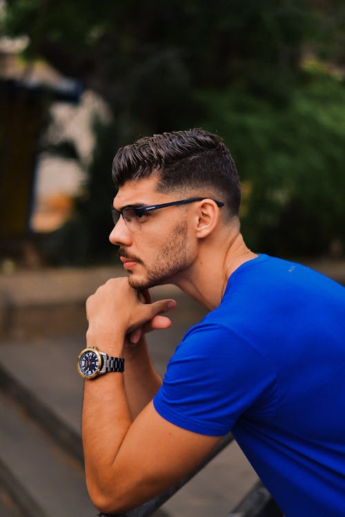 A man in a blue shirt and glasses