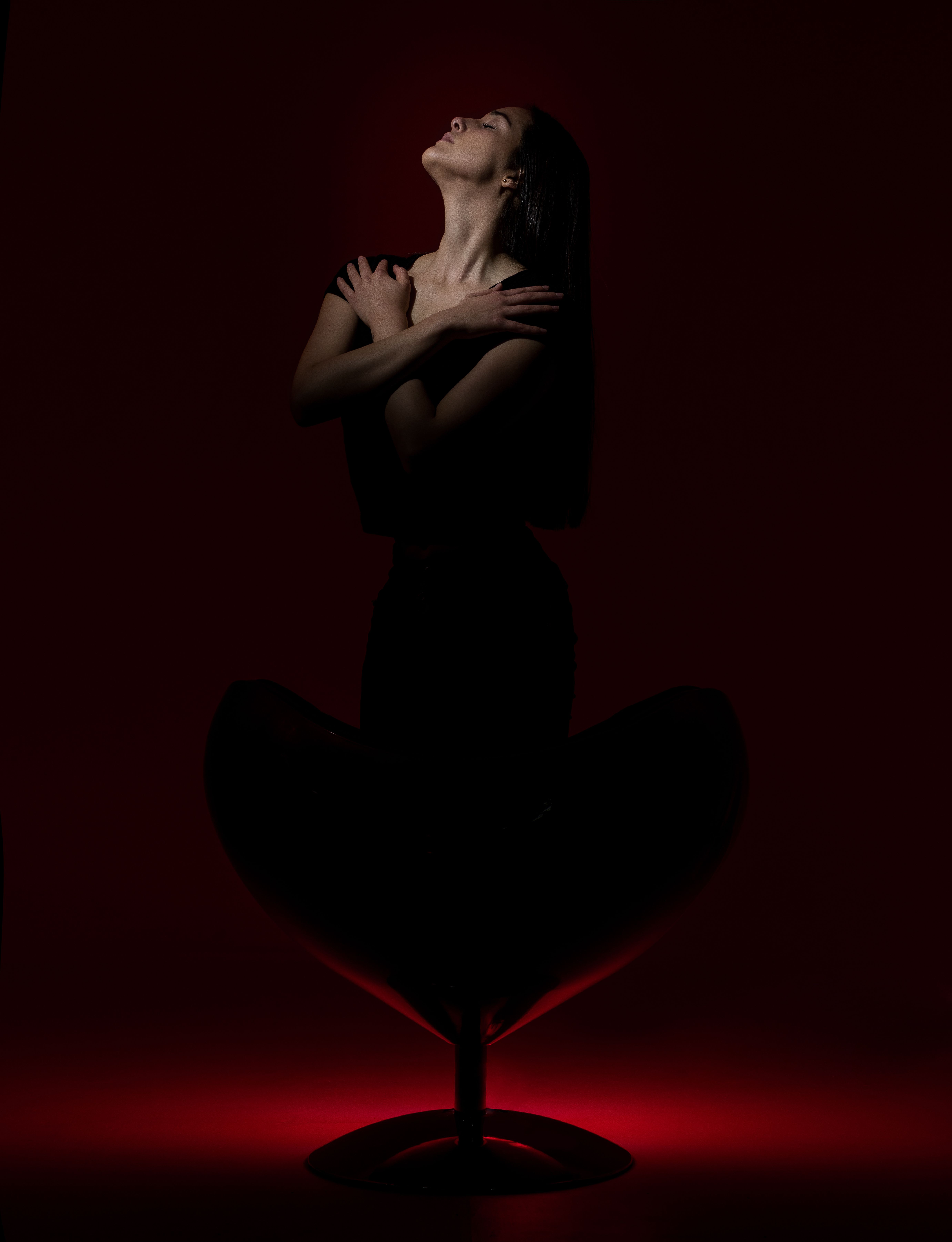Woman Kneeling and Posing on Chair in Darkness · Free Stock Photo