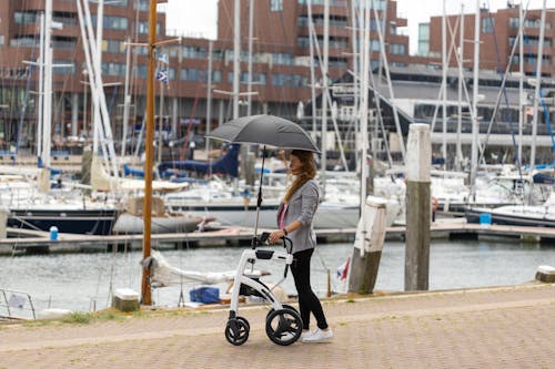 Woman standing with a rollator walker at a dock 
