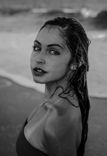 Elegant black and white portrait of a woman on the beach.