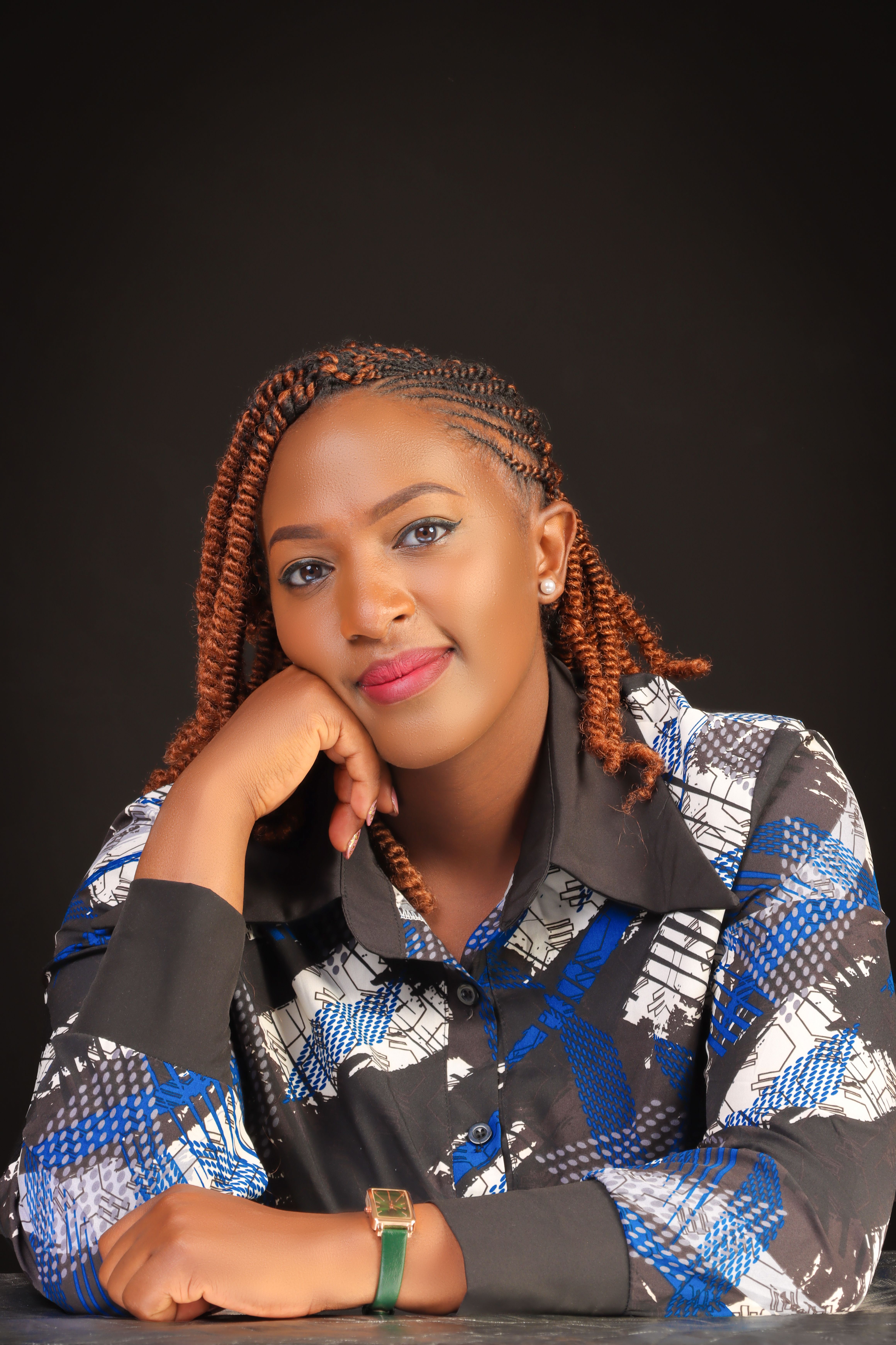 A stylish portrait of a confident woman with braided hair against a dark background.