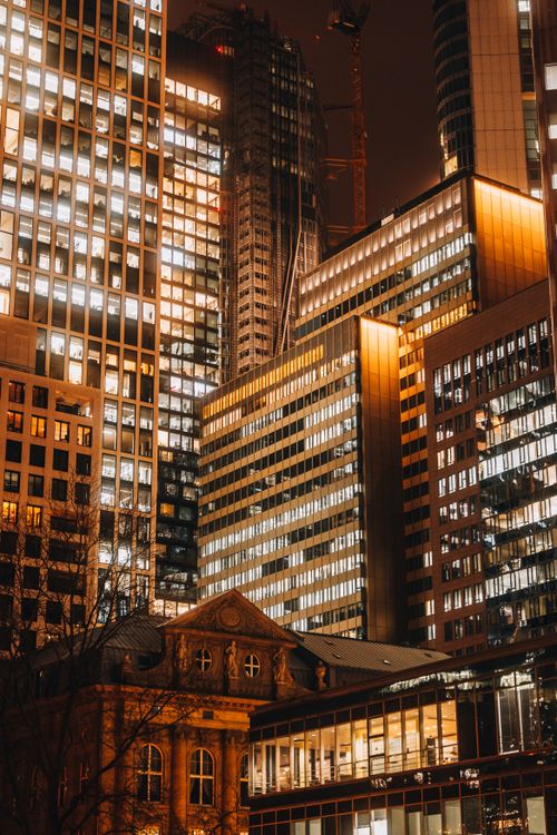 Free Stunning view of modern skyscrapers illuminated against the night sky, showcasing urban architecture. Stock Photo