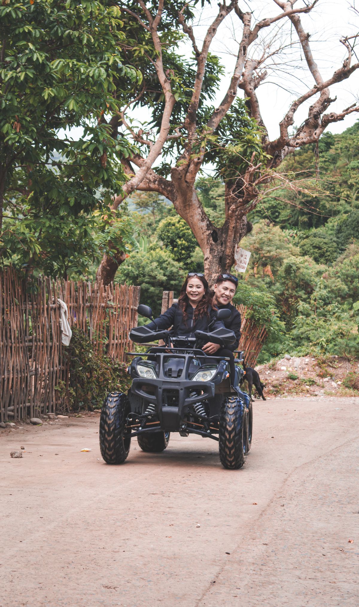 Couple riding a quad bike on a green countryside trail