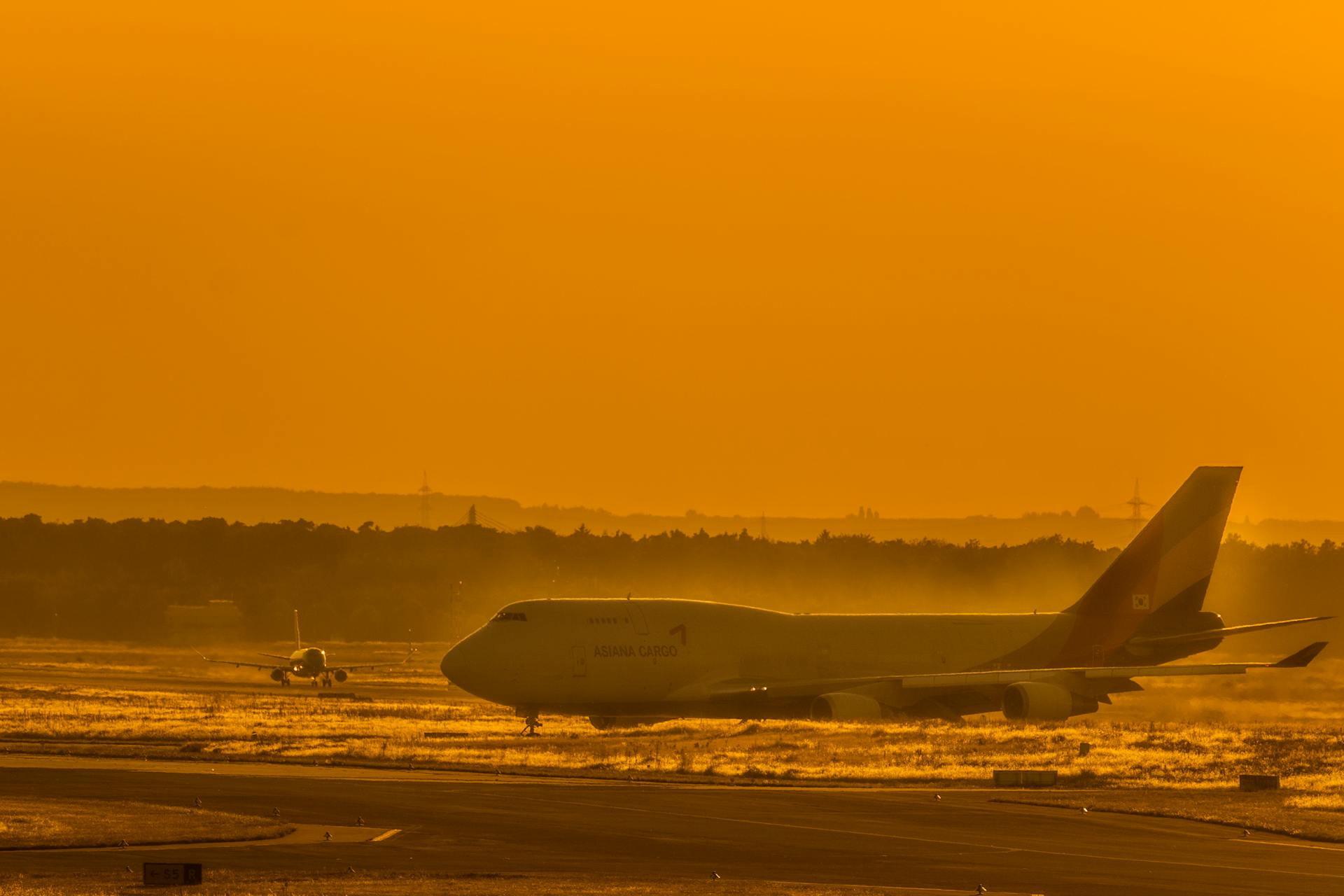 A freight aircraft on the runway at sunset, perfect for travel and aviation themes.