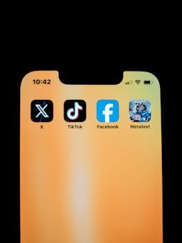 Close-up of smartphone displaying social media apps on a yellow background.