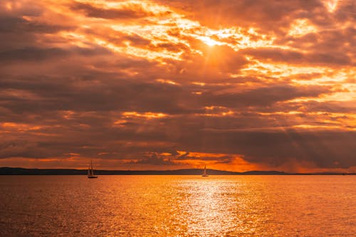 A boat is sailing in the ocean at sunset